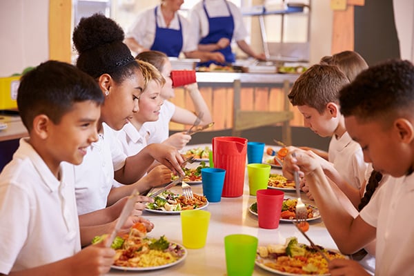 Niños y niñas comen en restaurante escolar