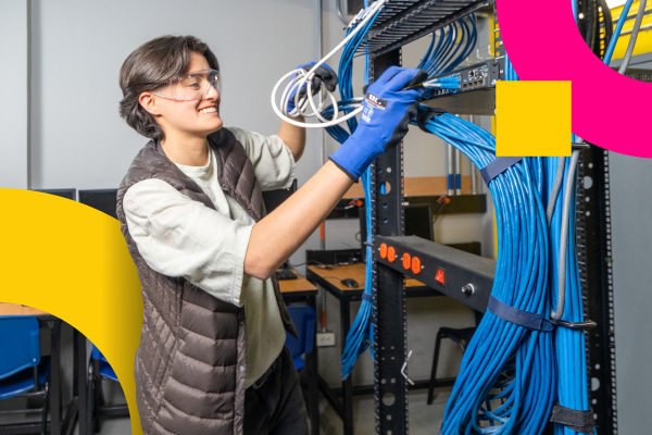 Joven conecta cables en un centro de datos como parte de su formación en tecnologías.