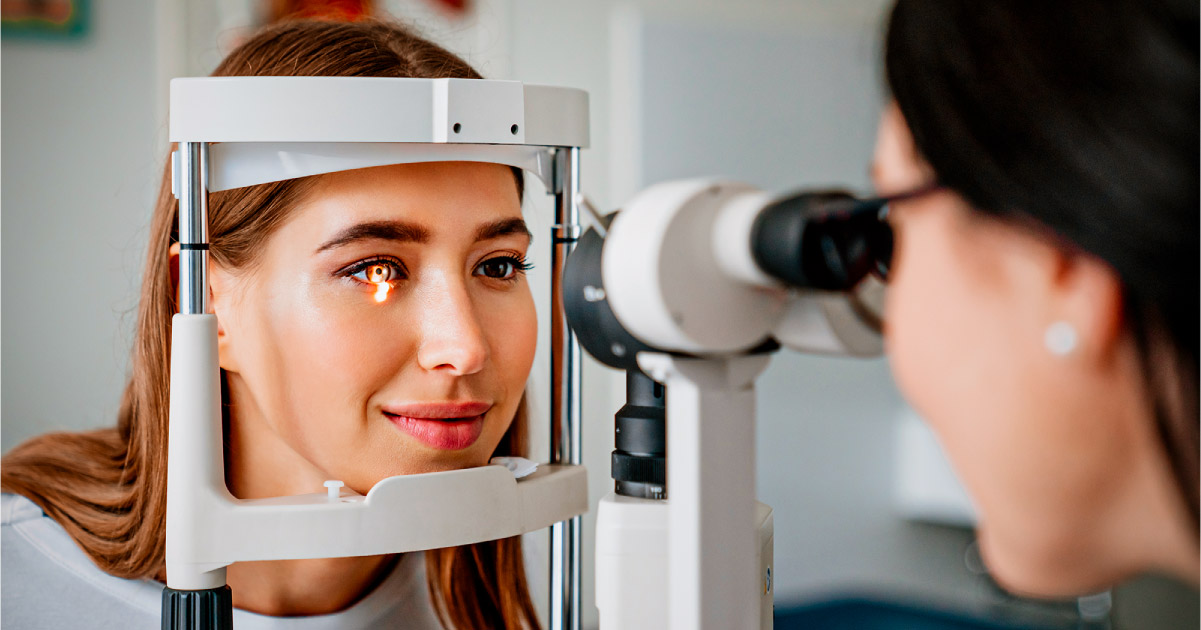 Mujer realizándose un examen oftamólogico con un profesional. 